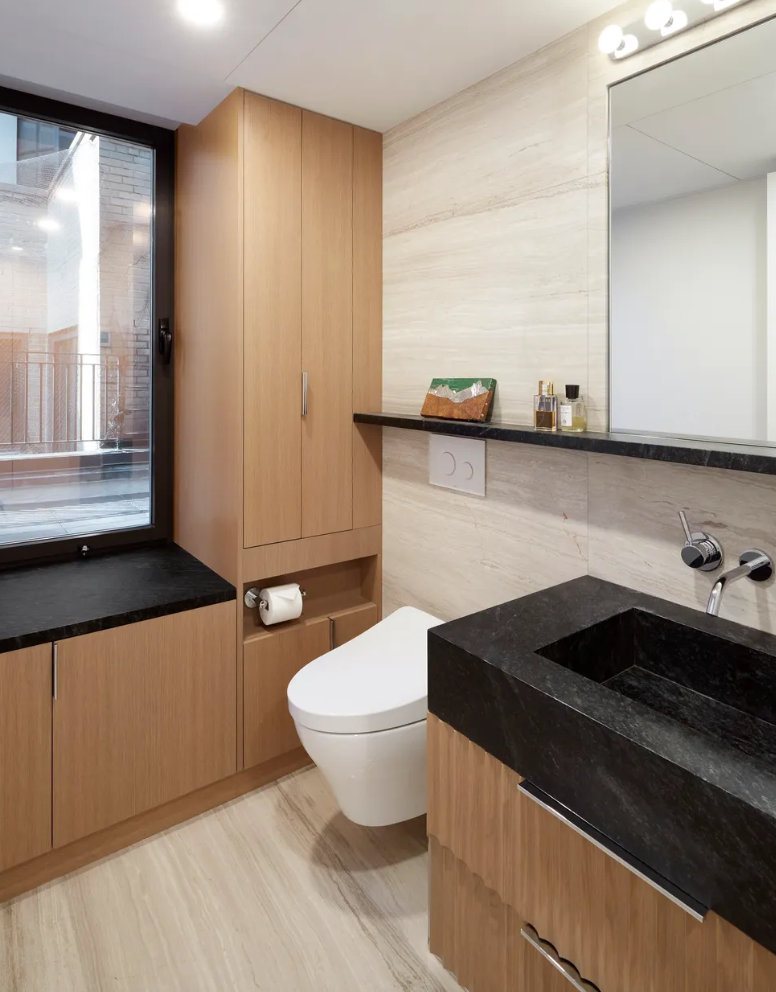 Close view of wood drawers under a dark stone sink
